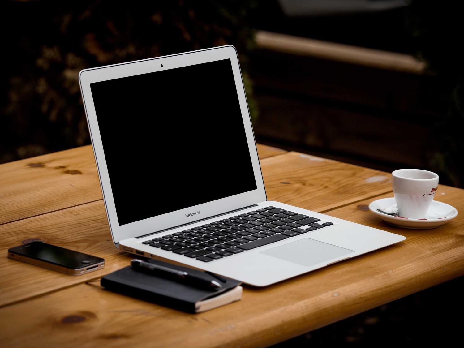 Portátil abierto sobre un escritorio junto a una taza de café